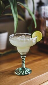 Chilled margarita in a glass garnished with a lime slice.
